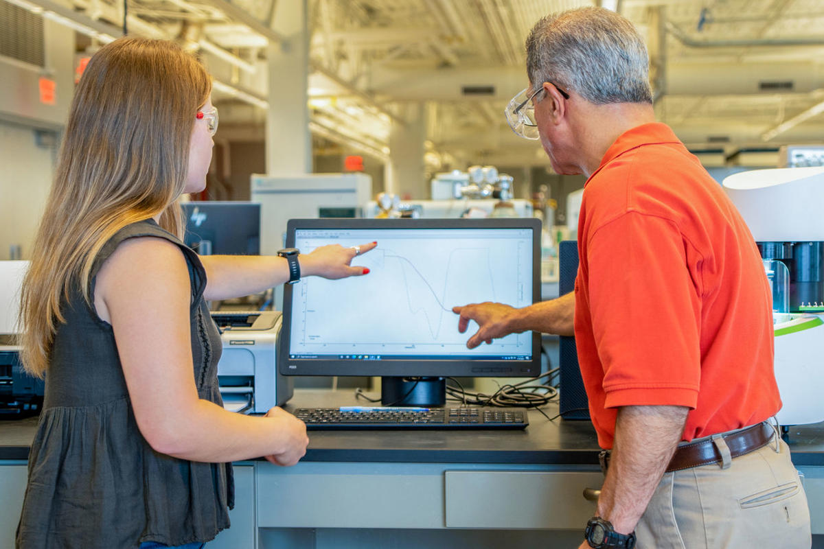 a man and woman looking at a computer screen