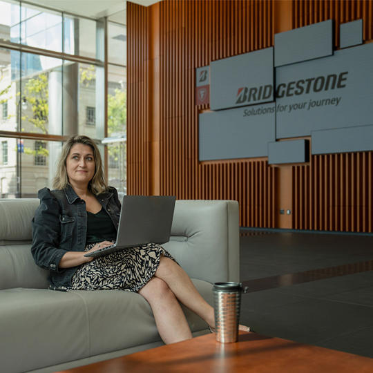 a woman sitting on a couch with a laptop