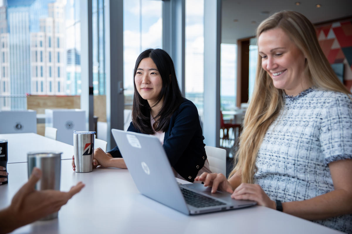 a group of women sitting at a table with a laptop